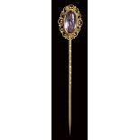 A modern amethyst intaglio set in a gold stick pin. Winged female figure.