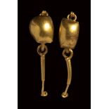 A roman pair of gold earring with discs and pendants.