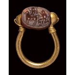 An etruscan carnelian scarab intaglio, mounted on an ancient gold ring. Warrior and Faun.