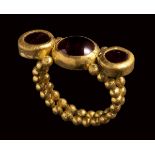 A late roman gold ring set with three garnets.