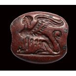 An archaic greek red jasper engraved seal. Seated sphinx.