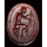 An etruscan carnelian scarab intaglio. Hermes with caduceus.