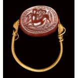 An etruscan carnelian scarab intaglio mounted on an ancient gold ring. Centaur.