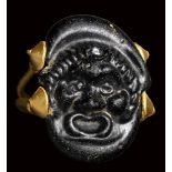 A rare roman black glass cameo set in an ancient gold ring. Theatrical mask.