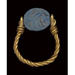 A phoenician blue glass paste scarab intaglio, mounted on an ancient gold ring. Quadrupede