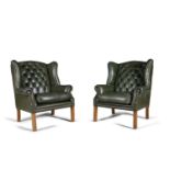 A PAIR OF GEORGIAN STYLE UPHOLSTERED WING BACK BUTTON ARMCHAIRS, covered in green hide and raised on