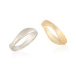 TWO GOLD RINGS, of wavy design, one mounted in 18K white gold, and the other mounted in 18K yellow