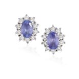 A PAIR OF TANZANITE EARSTUDS, each oval-shaped tanzanite within four claw-setting, to a surround