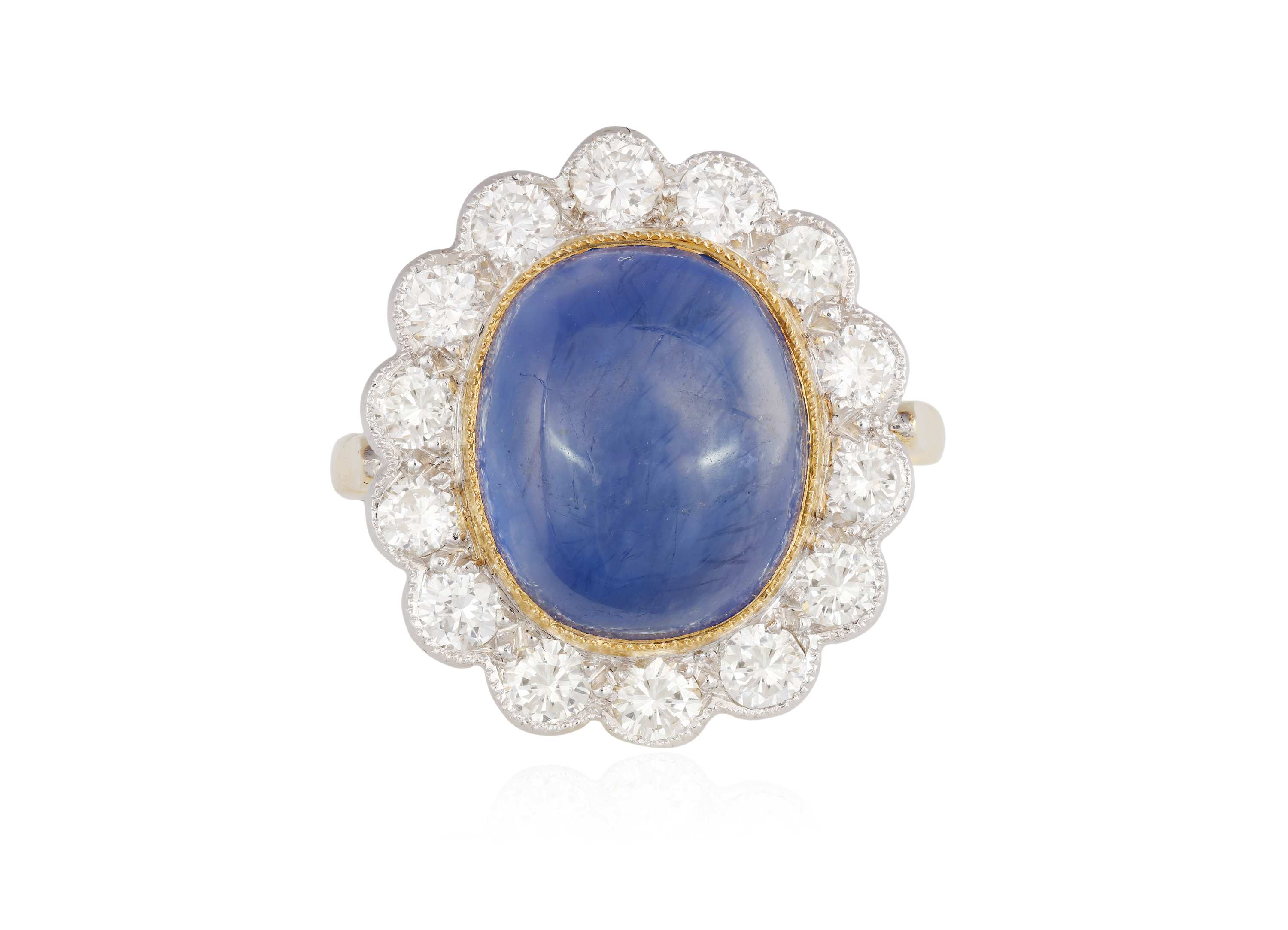 A SAPPHIRE AND DIAMOND CLUSTER RING, The oval-shaped cabochon sapphire weighing approximately 8.