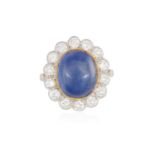A SAPPHIRE AND DIAMOND CLUSTER RING, The oval-shaped cabochon sapphire weighing approximately 8.