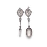 A PAIR OF 19TH CENTURY CONTINENTAL WHITE METAL ORNAMENTAL SERVING SPOONS AND MATCHING FORK, the flat