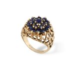 A SAPPHIRE COCKTAIL RING, CIRCA 1960, of openwork bombé textured gold design, centrally-set with
