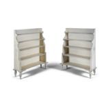 A PAIR OF 20TH CENTURY WHITE PAINTED GRADUATED BOOK SHELVES, raised on short rope-twist supports.