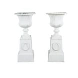 A PAIR OF WHITE PAINTED CAST IRON GARDEN URNS OF CAMPAGNA FORM, each raised on square tapering
