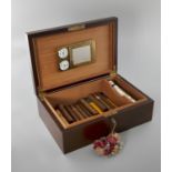 A WALNUT RECTANGULAR HUMIDOR with hinged lid containing an assorted 8 Cuban and other cigars, such