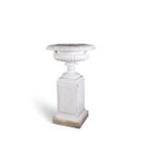 A VICTORIAN CAST IRON GARDEN URN, the broad top with everted rim above a waisted pedestal foot,