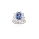 A SAPPHIRE AND DIAMOND CLUSTER RING, the oval-shaped sapphire weighing 4.11cts within a four-claw
