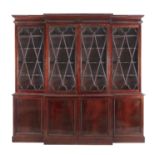 A GEORGE IV MAHOGANY BREAKFRONT BOOKCASE, the gadroon cornice above astragal glazed doors and