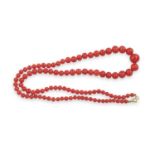 A CORAL BEAD NECKLACE, composed of a single row of graduating coral corallium rubrum beads, to an