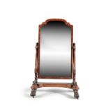 A VICTORIAN MAHOGANY FRAMED CHEVAL MIRROR, the shaped rectangular mirror with domed top, supported