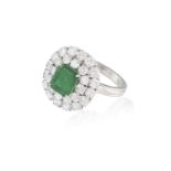 AN EMERALD AND DIAMOND CLUSTER RING, the rectangular cut-cornered emerald weighing approximately 1.