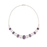A VICTORIAN AMETHYST NECKLACE, the frontispiece set with graduated oval-shaped amethysts