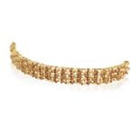 A RUBY AND DIAMOND BRACELET BY WEST, CIRCA 1970 Of openwork textured gold design, set throughout