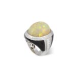 AN OPAL, DIAMOND AND ONYX COCKTAIL RING The oval-shaped cabochon opal weighing approximately 30.