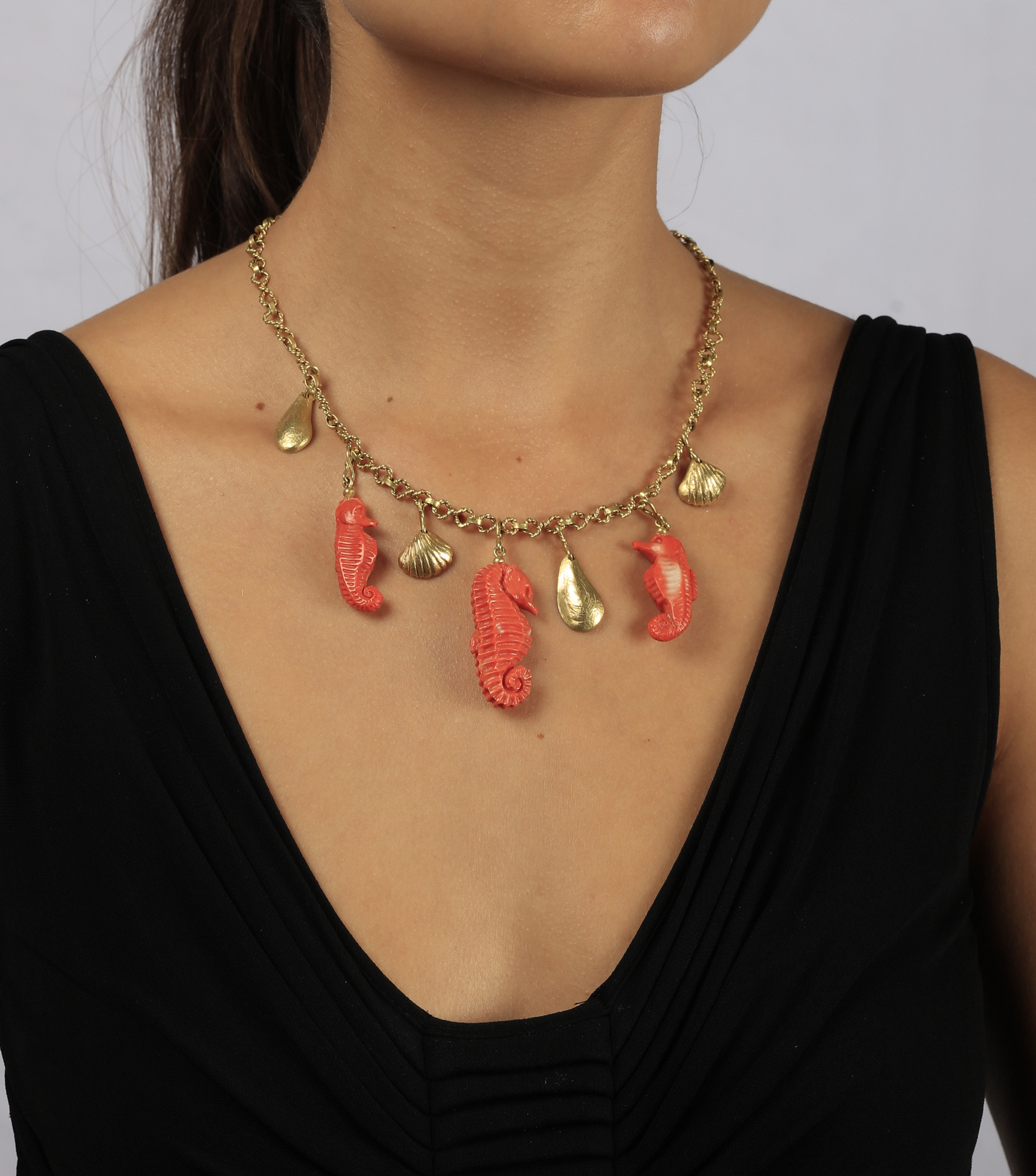 A CORAL AND GOLD CHARM NECKLACE, CIRCA 1960 The fancy-link chain with ropetwist detail suspending - Image 2 of 2