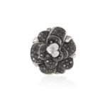A DIAMOND FLOWER COCKTAIL RING Designed as a Camelia rose flowerhead, the pistil set with a trio