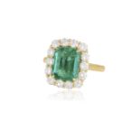 A FINE EMERALD AND DIAMOND CLUSTER RING The cushion-shaped emerald weighing 3.33cts set in a four-