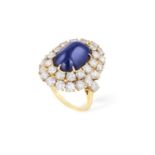 A SAPPHIRE AND DIAMOND CLUSTER RING, BY BOUCHERON The central sugarloaf sapphire cabochon weighing