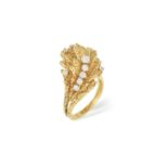 A DIAMOND RING, CIRCA 1970 Of abstract floral design, the textured gold leaves highlighted with