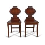 A PAIR OF MAHOGANY HALL CHAIRS BY GILLOWS OF LANCASTER, the balloon shaped backs, with reeded scroll