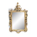 A GEORGE III STYLE CARVED GILTWOOD WALL MIRROR,in the Rococo taste, the shaped rectangular mirror