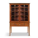 A PAINTED SATINWOOD DISPLAY CABINET, the top section with twin glazed doors opening to reveal a