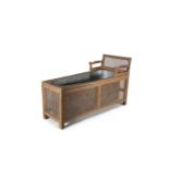 A 19TH CENTURY OAK FRAME METAMORPHIC DAY BED, with cane panels enclosing a copper bath. 88cm tall