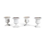FOUR WHITE PAINTED CAST IRON GARDEN URNS, 19TH CENTURY, of campagna form, each with everted rims,