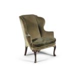 A GEORGE III MAHOGANY FRAMED WING BACK ARMCHAIR, upholstered in moss green fabric, on cabriole