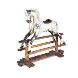 A 19TH CENTURY PAINTED TIMBER ROCKING HORSE, on a hinged swing support with pendulum movement. 128cm