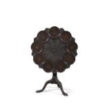 A GEORGIAN MAHOGANY SHAPED CIRCULAR TEA TABLE, the top centred by carved acanthus rosette within a