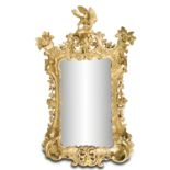 AN IRISH CARVED GILTWOOD MIRROR, C.1760, the prominent pierced cresting surmounted by a displayed