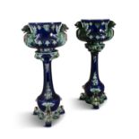 A NEAR PAIR OF VICTORIAN MAJOLICA JARDINIERE POTS AND STANDS, each in royal blue, green and cream