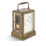 A FRENCH GILT BRASS CARRIAGE CLOCK, c.1900, with white enamel dial and carrying handle. 13cm high (