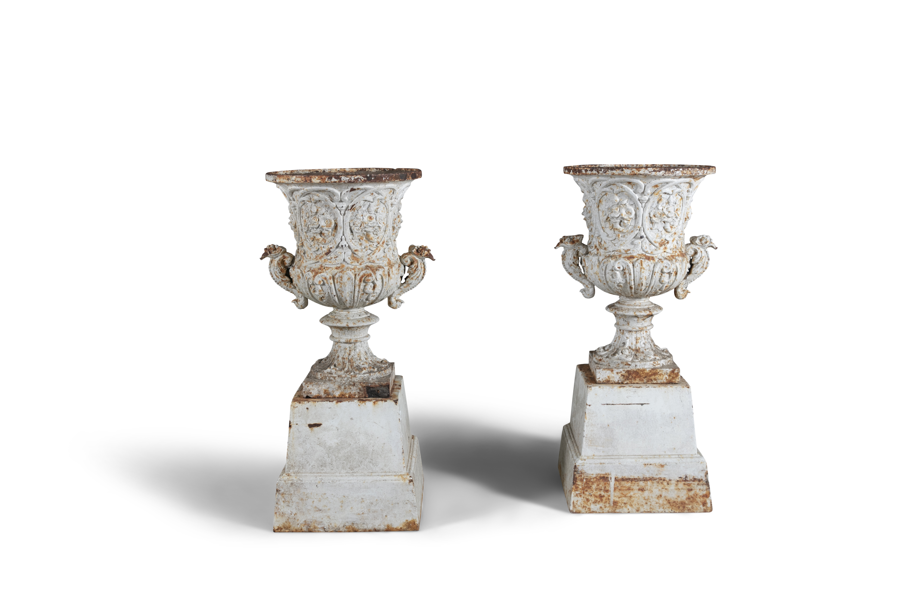 A PAIR OF VICTORIAN CAST IRON FLARED RIM GARDEN URNS, the bodies with scroll and foliate bodies,