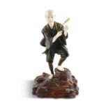 A LARGE JAPANESE BRONZE AND IVORY OKIMONO, 19th century, modelled as a standing musician, carrying a