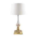 A cast brass and milk glass table lamp, the circular baluster column with gilded decoration, on a