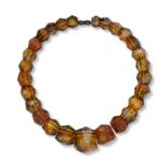 AN AMBER BEAD NECKLACE, the graduated fancy-shaped amber bead, inner diamater approx. 15cm