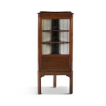 AN EDWARDIAN MAHOGANY CORNER CABINET, with glazed nine panelled door, enclosing a shelved and fabric