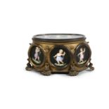 A LARGE BRASS FRAMED SEWING BOX WITH PAINTED PORCELAIN VIGNETTES, of oval form, the hinged lid